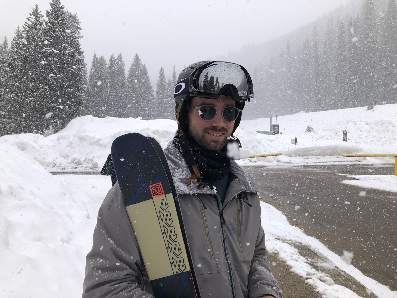 Patrick Dayton holding his skis on a snowy mountain day